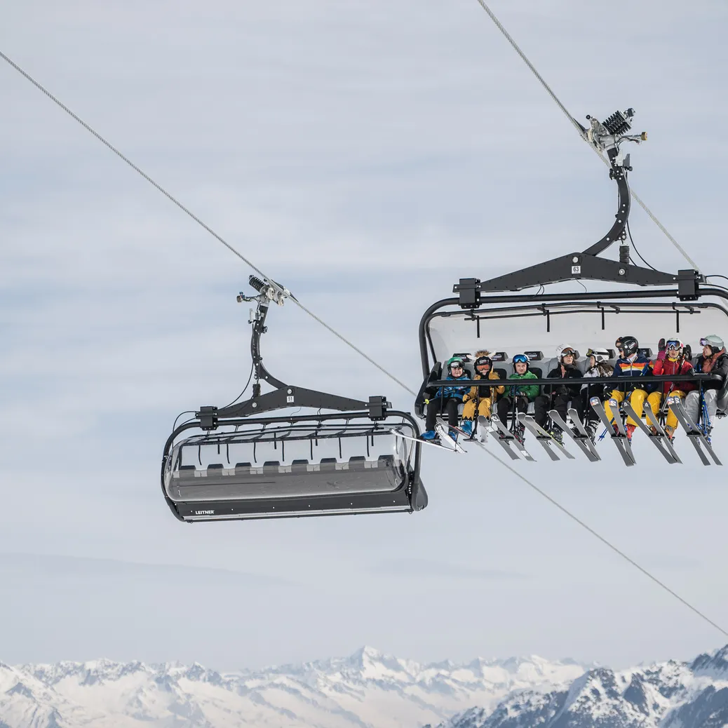 Due seggiovie con sciatori al Klausberg davanti al panorama montano in inverno