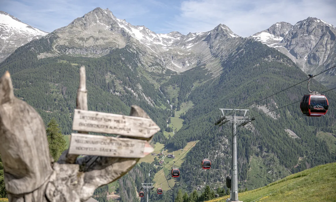 Klausberg K-Express Gondelbahn im Sommer mit Wanderwegweiser und Blick ins Ahrntal