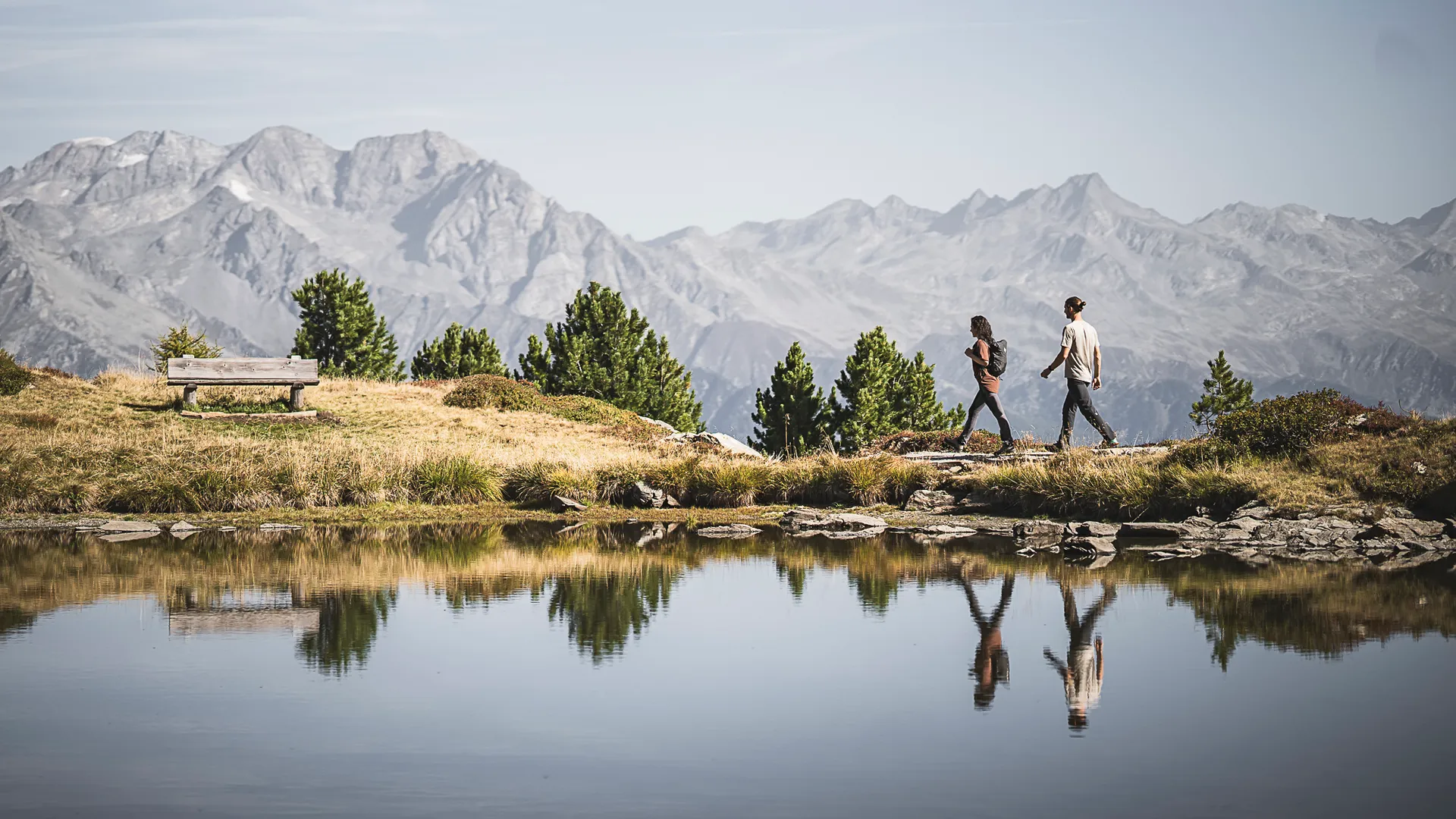 Wanderpaar am Bergsee am Speikboden mit Spiegelung und Panorama der Zillertaler Alpen