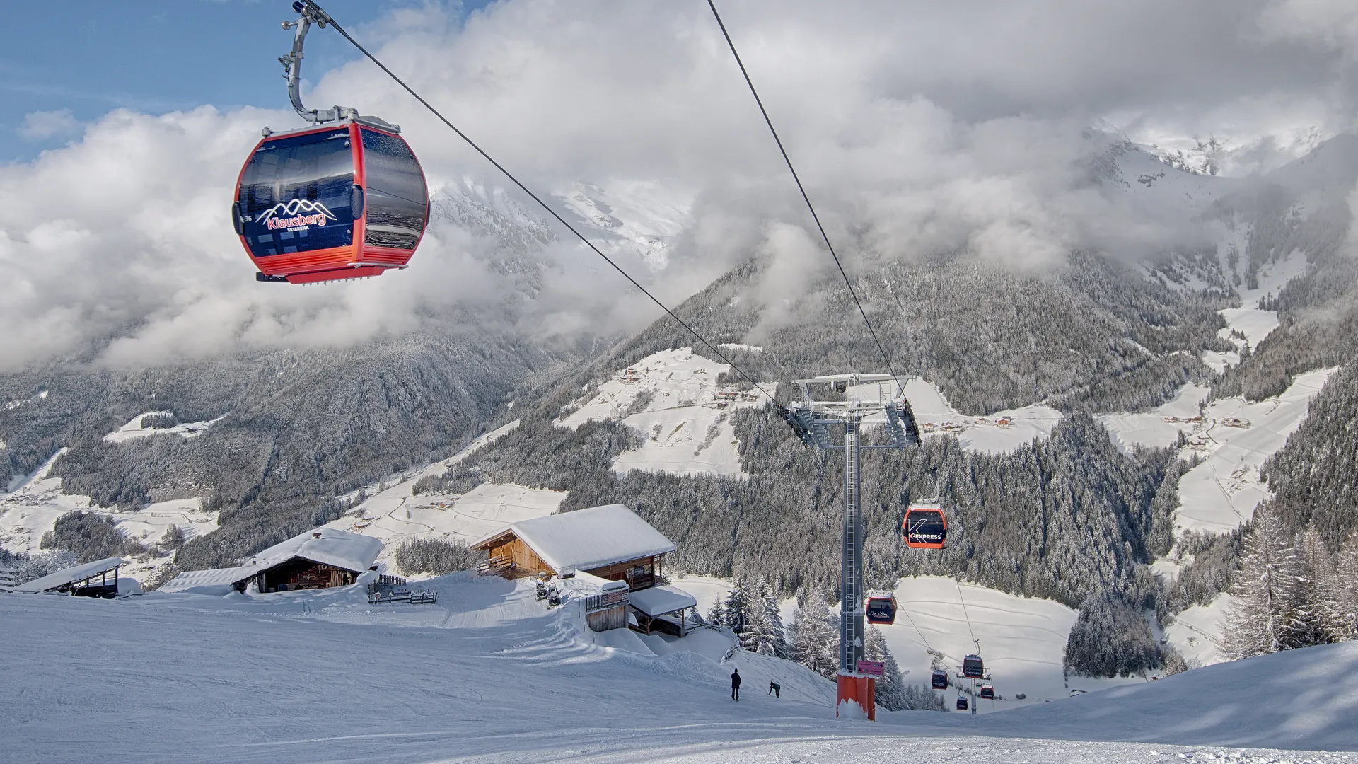Skier making dynamic carving turn on Klausberg slope with Zillertal Alps panorama