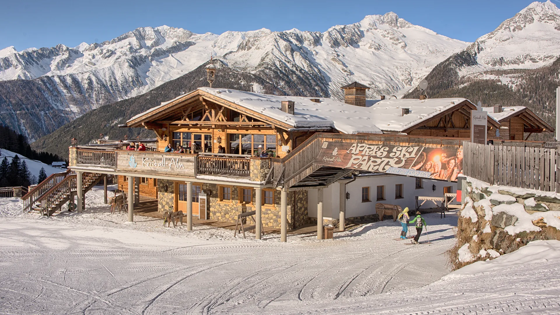 Kristall Alm am Klausberg mit Sonnenterrasse, Skifahrern und verschneitem Bergpanorama