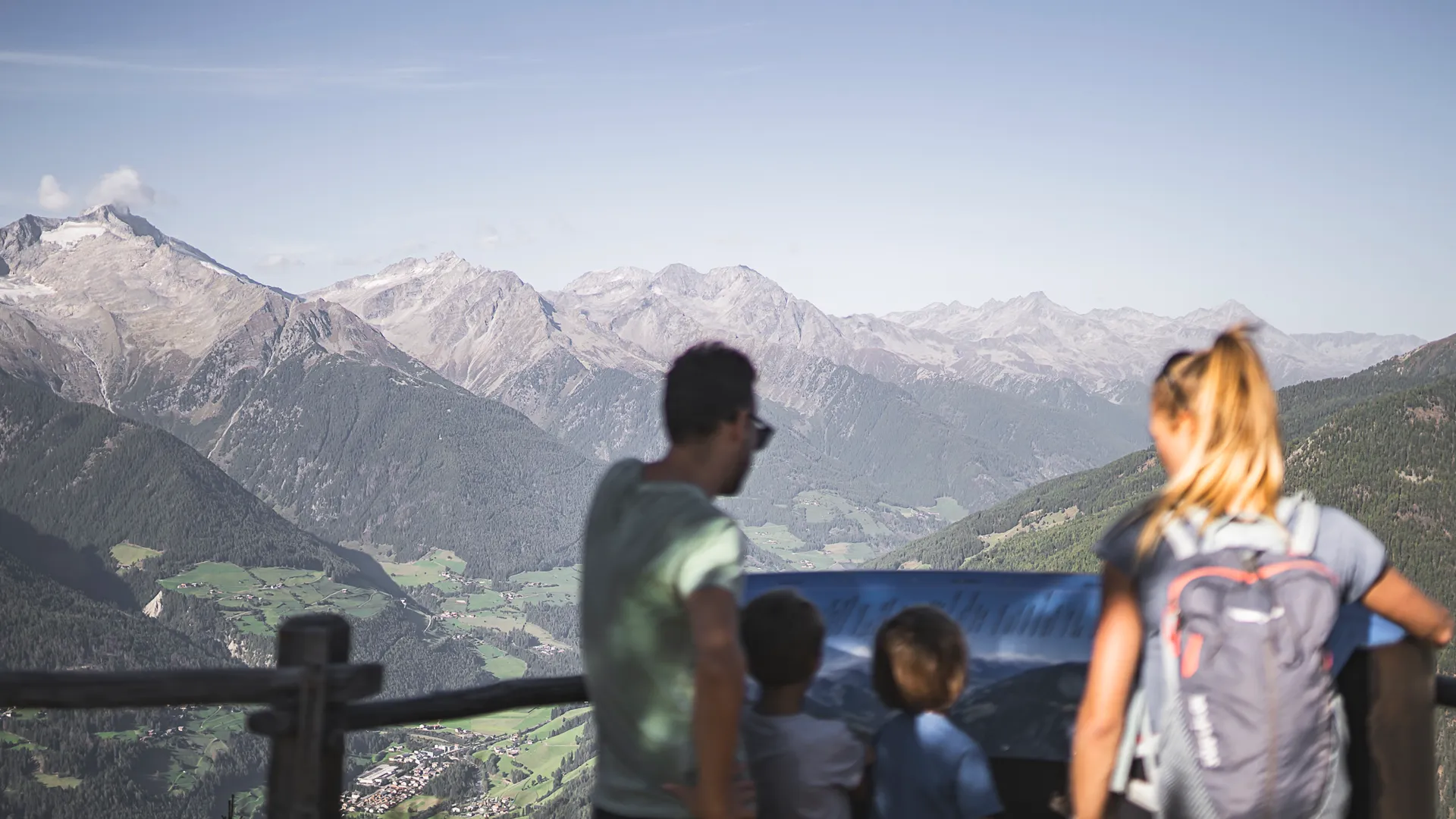 Familie am Aussichtspunkt mit Panoramatafel und Blick auf das Ahrntal und die Zillertaler Alpen