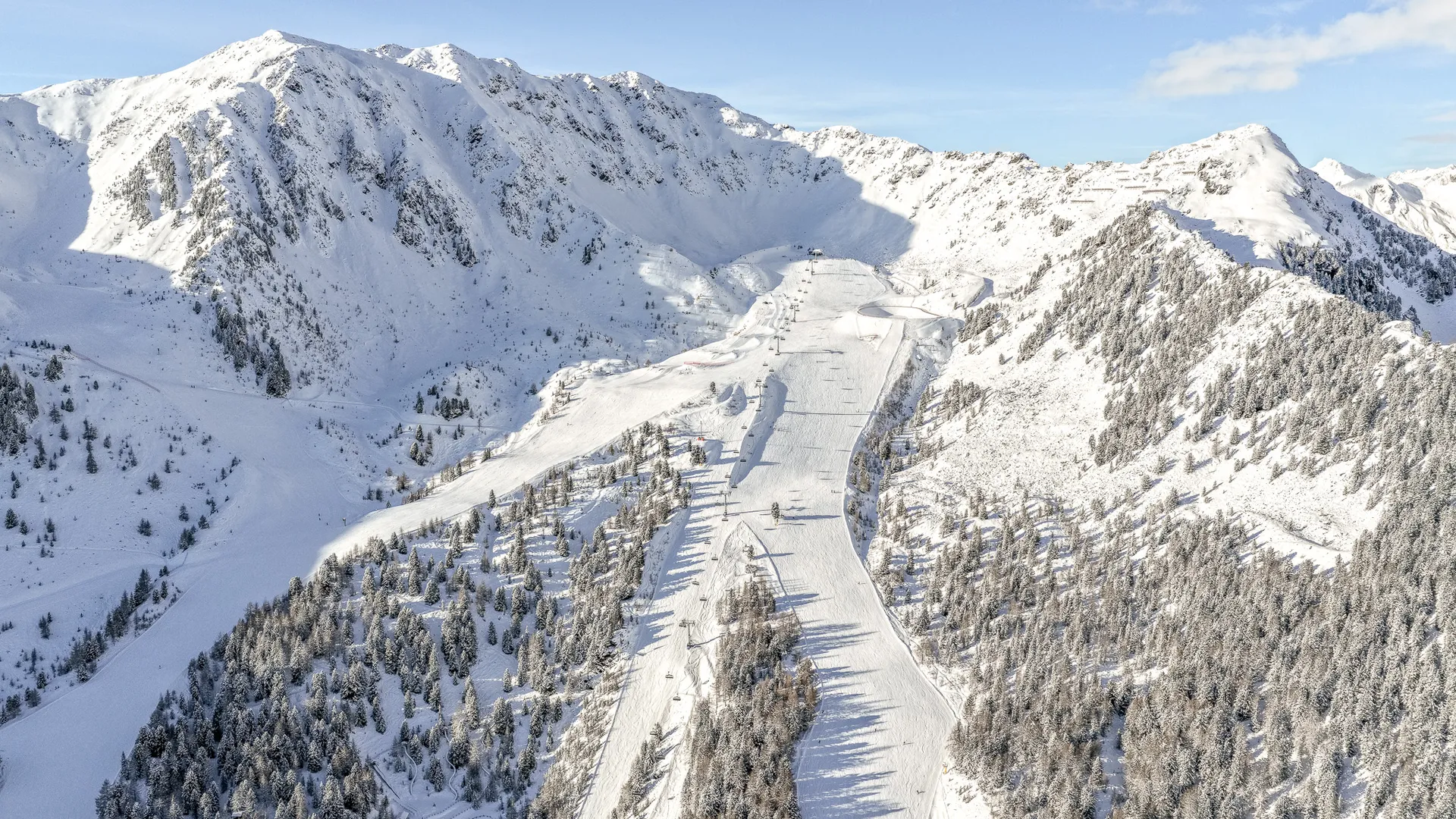 Luftaufnahme der weitläufigen Skipisten am Speikboden mit verschneiten Gipfeln des Ahrntals