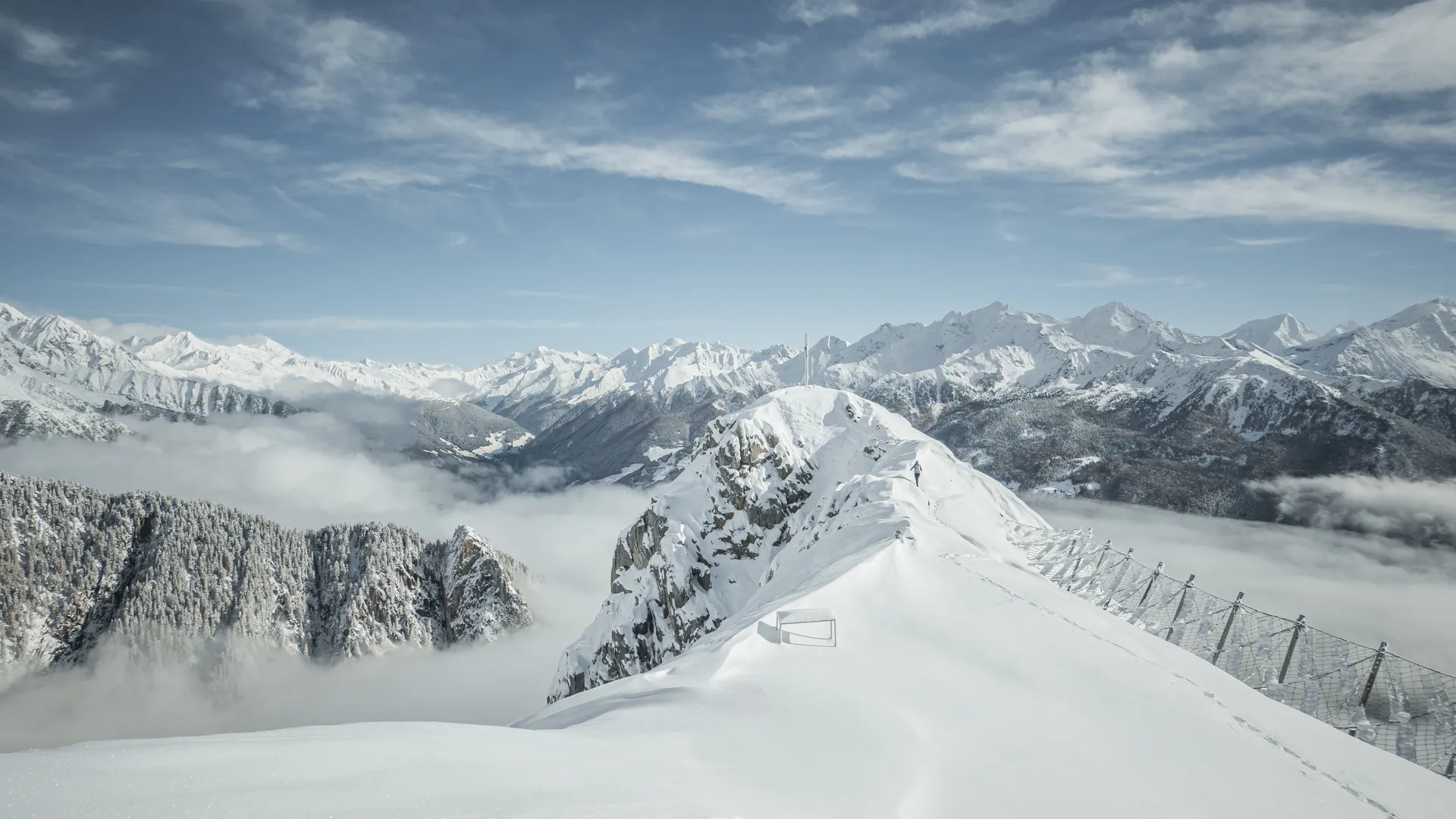 Verschneiter Gipfelgrat mit Lawinenzäunen über dem Nebelmeer im Ahrntal, Zillertaler Alpen