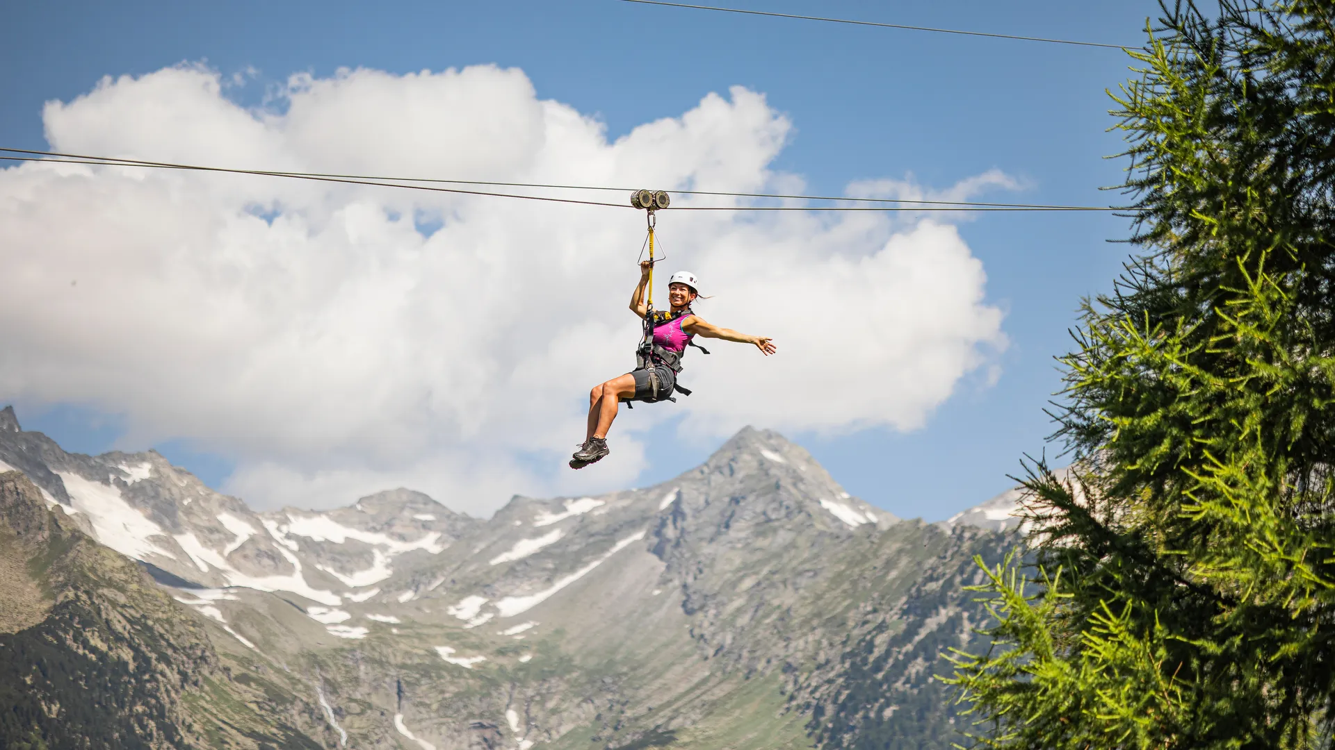 Frau am Skyglider Zipline am Klausberg vor schneebedeckter Zillertaler Alpenkette