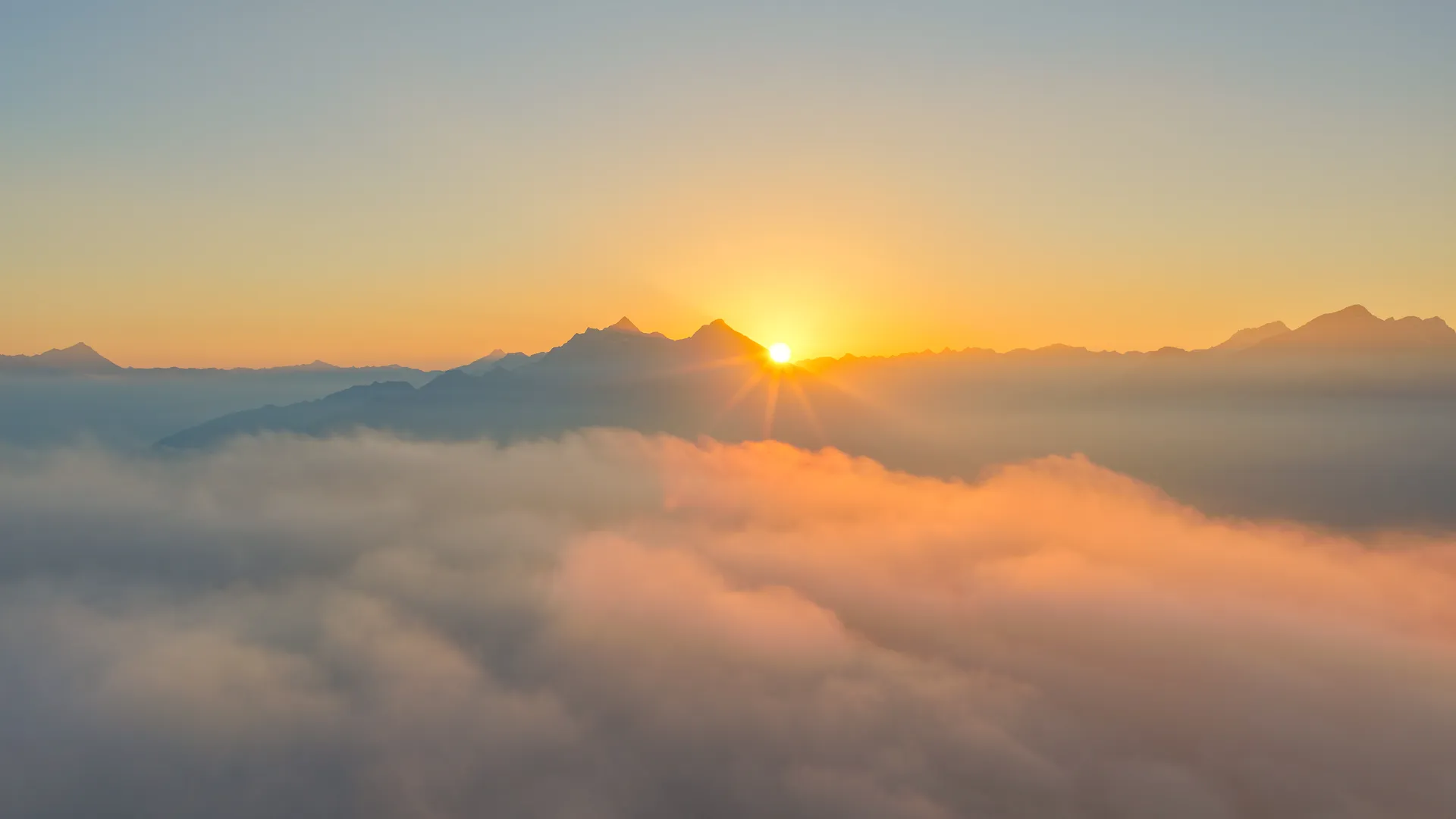 Spectacular sunrise over the three-thousanders of the Zillertal Alps with a dense sea of clouds in the valley