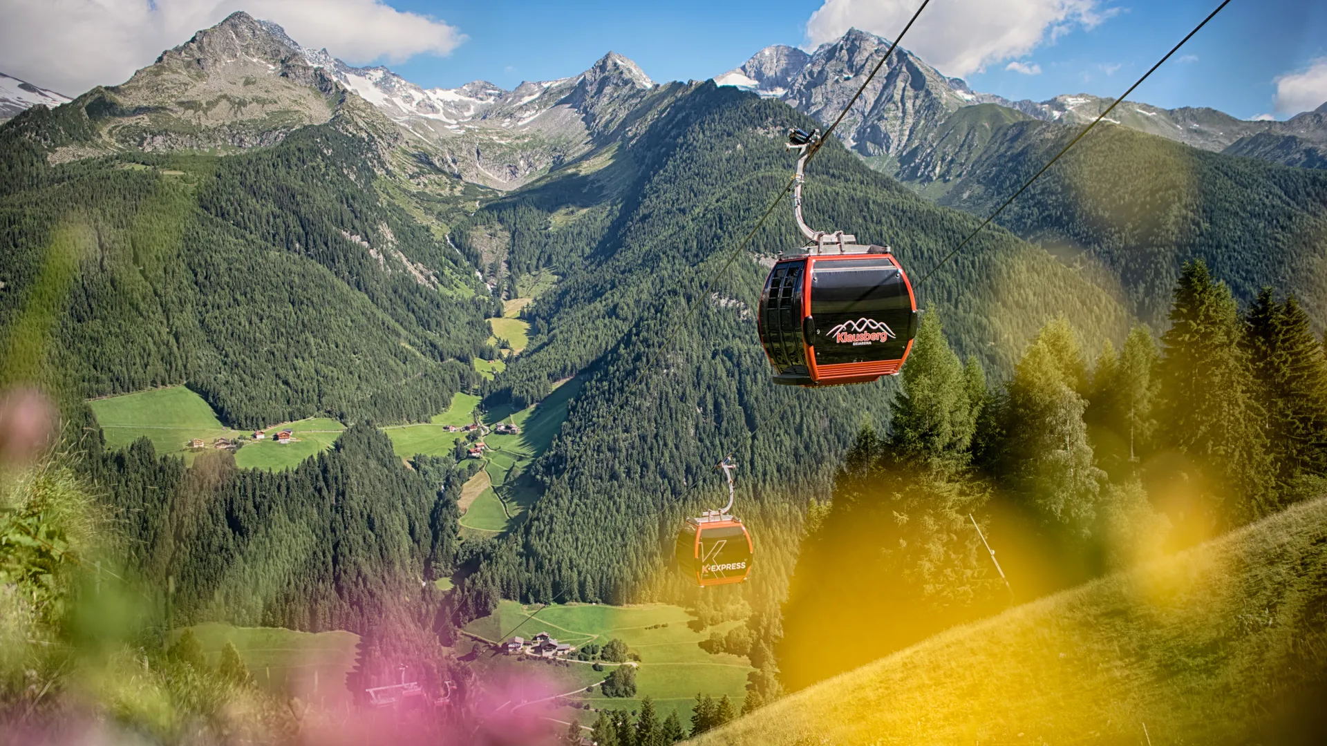Klausberg Express Gondelbahn über dem grünen Ahrntal mit Zillertaler Alpen im Sommer