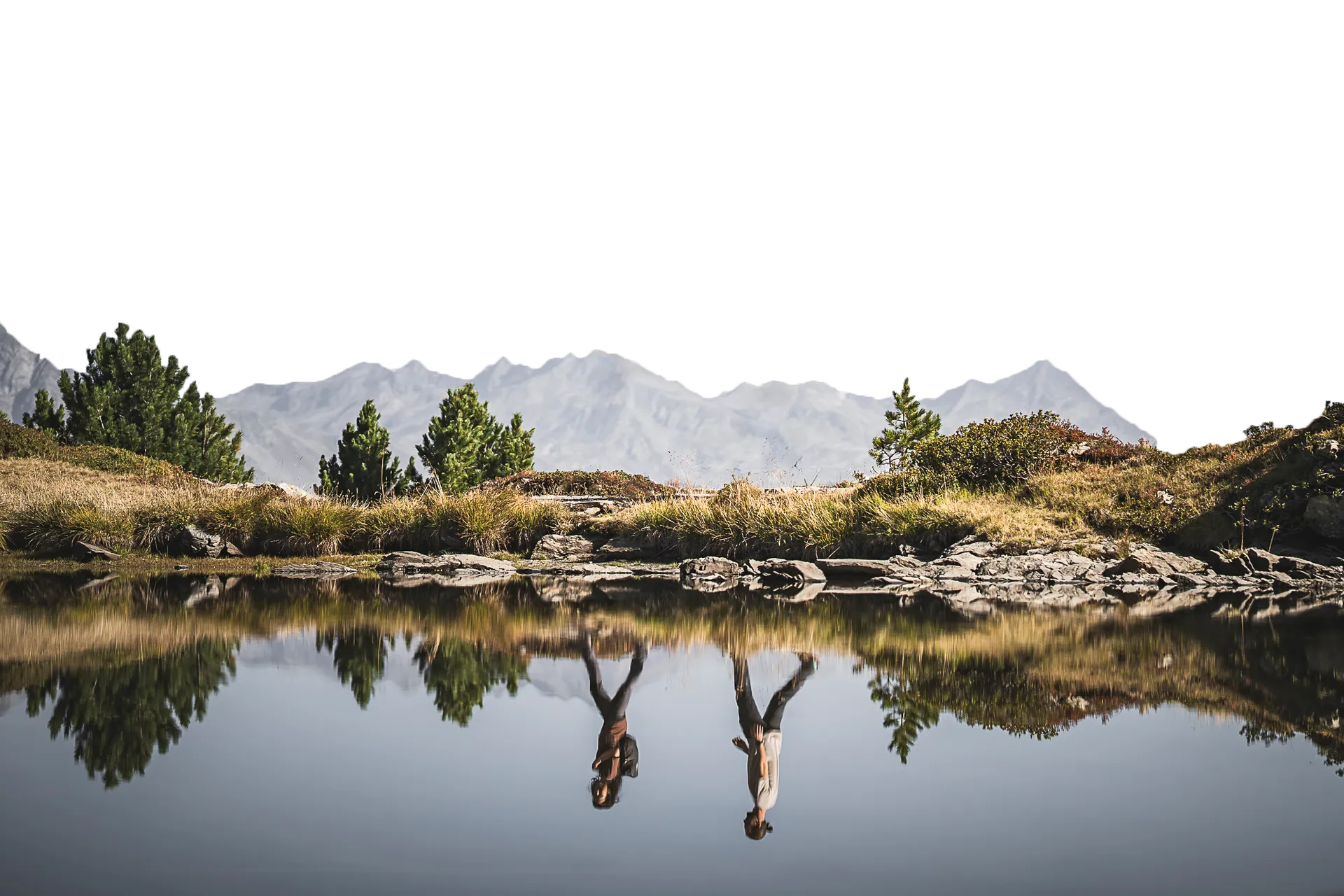 Spiegelung von Wanderern im Bergsee am Klausberg im Ahrntal