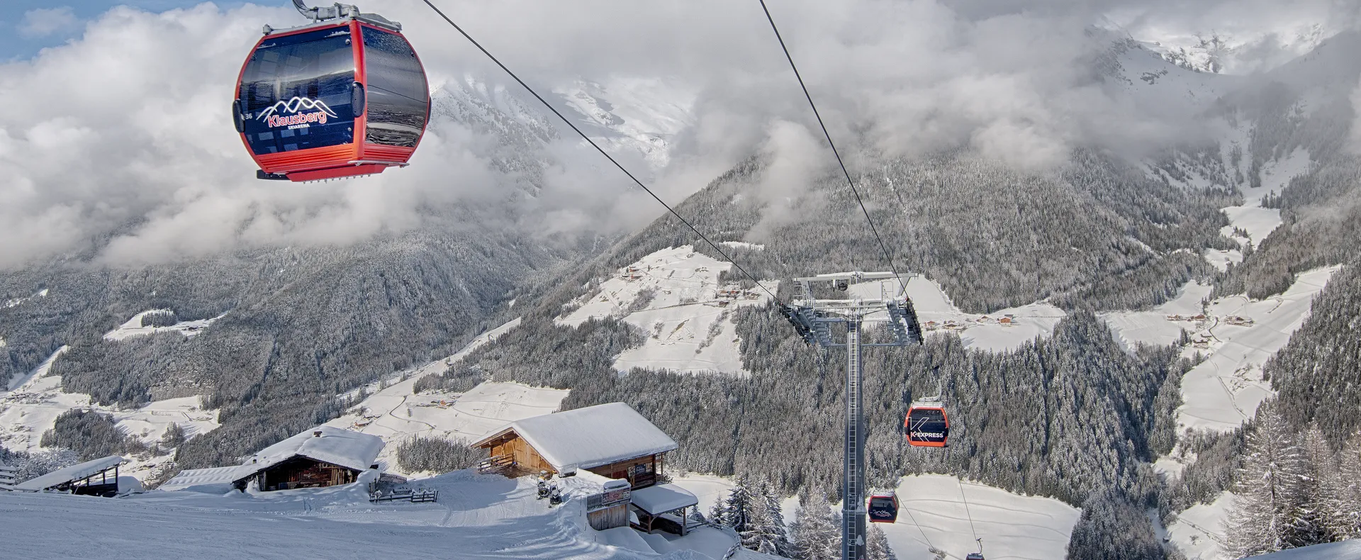 Skier making dynamic carving turn on Klausberg slope with Zillertal Alps panorama