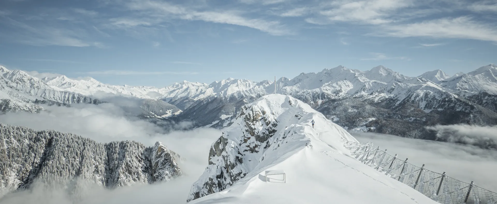 Verschneiter Gipfelgrat mit Lawinenzäunen über dem Nebelmeer im Ahrntal, Zillertaler Alpen