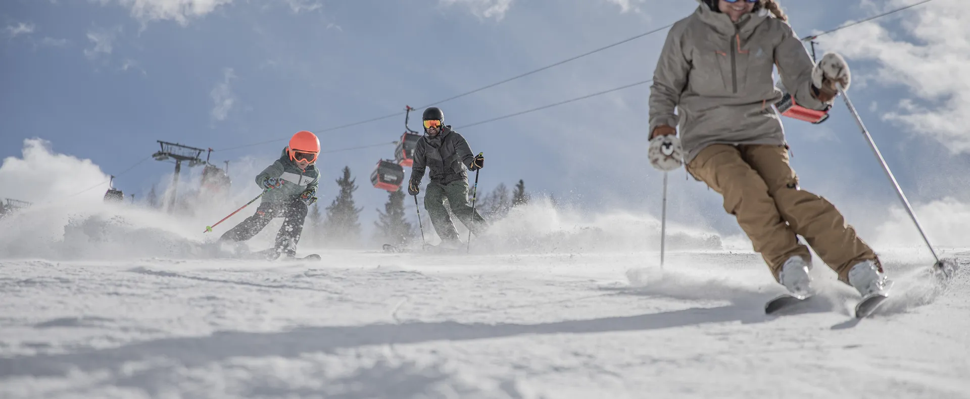 Familie mit Kind fährt auf sonniger Piste am Klausberg bei blauem Himmel Ski