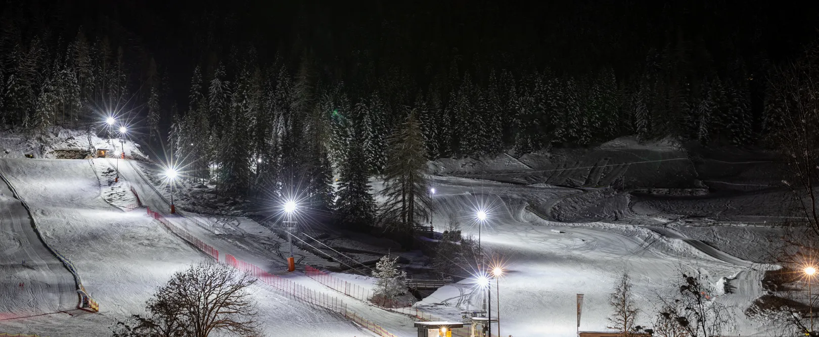 Illuminated ski slope for night skiing at Klausberg with ski rental and snowy forest