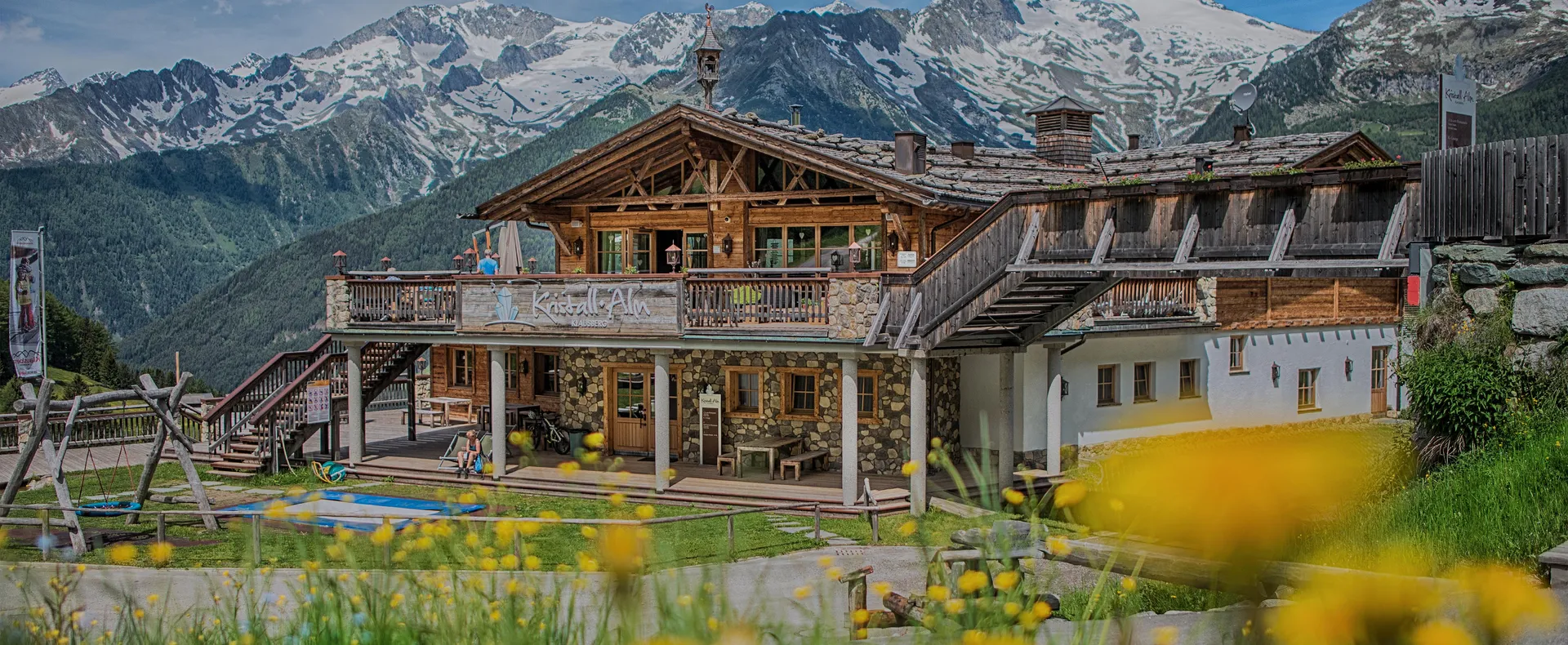 Kristall-Alm am Klausberg mit Holzterrasse und Panoramablick auf die Zillertaler Alpen im Sommer