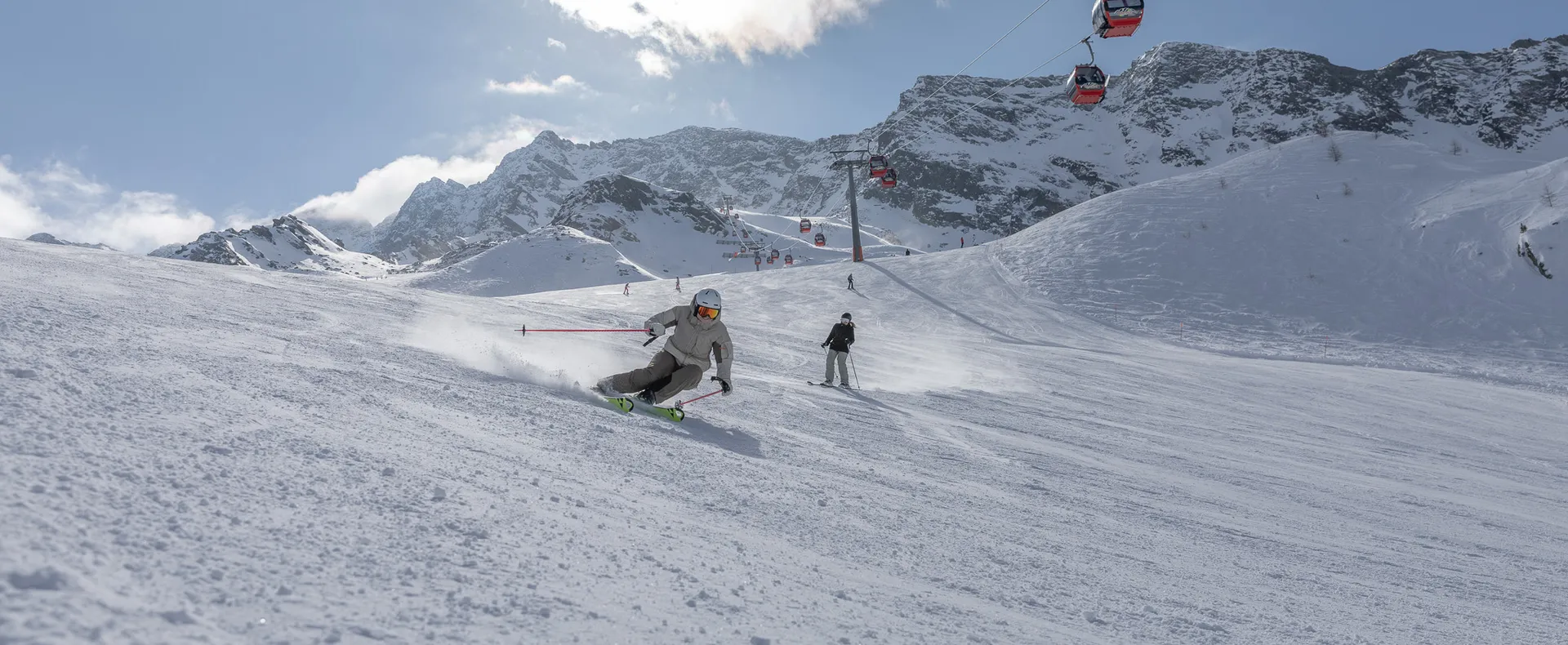 Skier in a dynamic carving turn on a groomed slope at Speikboden in Ahrntal