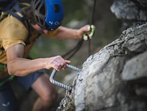 Hand greift Stahlgriff am Klettersteig Speikboden — Detailaufnahme Klettertechnik
