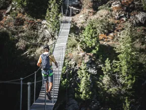 Kletterer überquert Holz-Hängebrücke am Klettersteig Speikboden im Sommer