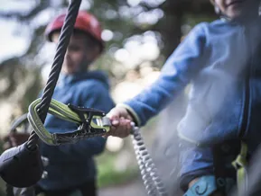 Karabiner am Stahlseil des Klettersteigs — Kinder beim Klettern am Speikboden