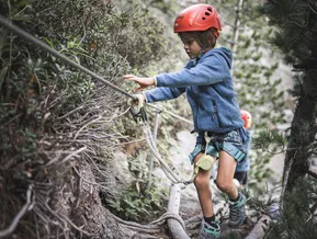 Kind im Klettersteig-Gurt am Speikboden Abenteuerweg im Sommer