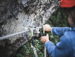 Kind sichert Karabiner am Klettersteig-Seil — Sicherheitstechnik am Speikboden