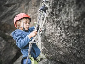 Kind klippt Klettersteig-Set ins Stahlseil — Sicherheitstechnik am Speikboden