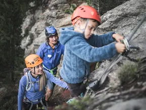 Geführter Klettersteig am Speikboden — Kind mit Bergführern am Fels
