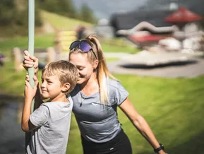 Child and companion at summer playground at Speikboden mountain station