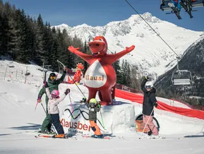 Familie jubelt mit Maskottchen Klausi an der Klausberg Skiarena – buntes Familienerlebnis im Skigebiet