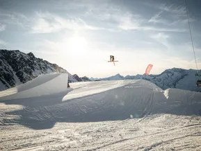 Freestyle-Skifahrer beim Rotation-Trick im Snowpark Klausberg mit Bergpanorama und Gondel