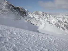 Freerider im Tiefschnee mit Panorama auf das verschneite Hochgebirge am Klausberg Ahrntal