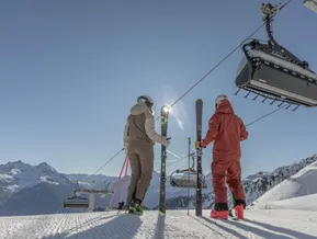 Zwei Skifahrer an der Bergstation der Sesselbahn am Speikboden mit Blick auf Südtiroler Alpen