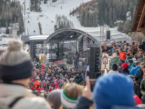 Open-Air-Bühne mit Live-Musik vor verschneiter Piste und Gondelbahn am Klausberg im Skigebiet Ahrntal