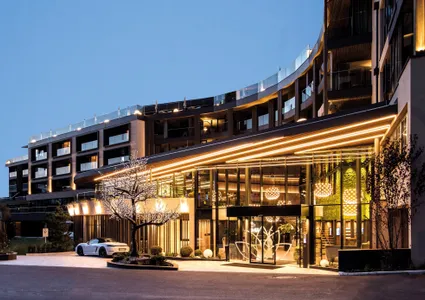 Luxushotel Eingangsbereich im Ahrntal mit Sportwagen bei Abenddämmerung