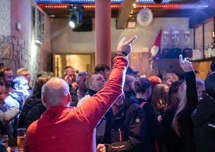 Après-Ski Party in der Hütte – Gäste feiern ausgelassen mit Stimmungsbeleuchtung