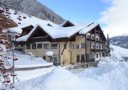 Verschneites Hotel im Ahrntal bei Sonnenschein – Winterurlaub Südtirol