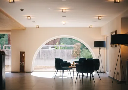 Moderne Hotel-Lounge mit Bogenfenster und Sesseln im Ahrntal