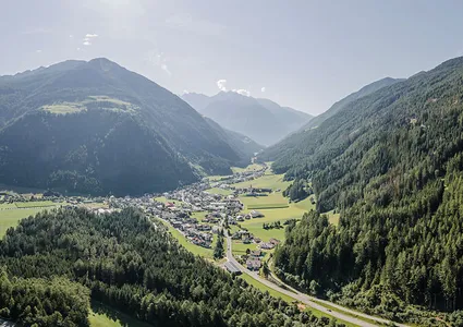 Luftaufnahme Ahrntal im Sommer mit sattgrünen Wiesen, Dorf und Nadelwäldern im Talkessel