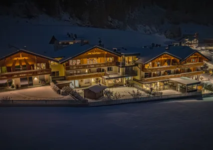 Beleuchtete Chalet-Anlage im Schnee bei Nacht im Ahrntal Südtirol