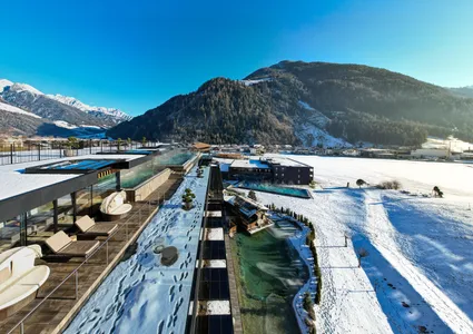 Luftaufnahme Spa-Anlage mit beheizten Pools im verschneiten Ahrntal