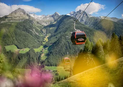 Klausberg Express Gondelbahn über dem grünen Ahrntal mit Zillertaler Alpen im Sommer