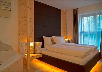 Gemütliches Hotelzimmer mit Zirbenholz, Doppelbett mit Ambientebeleuchtung und Whirlpool in Südtirol