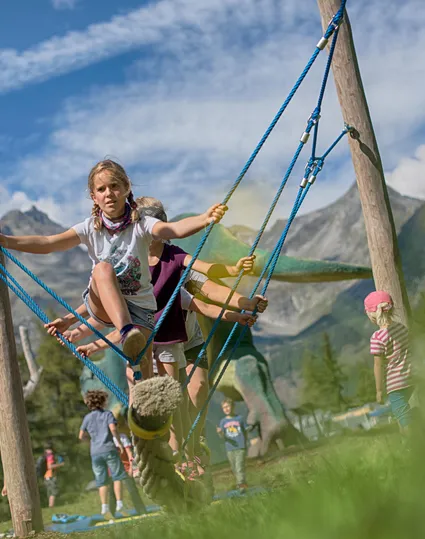Kinder spielen auf Seilschaukel am Erlebnispark Klausberg mit Dinosaurier-Figur und Bergpanorama