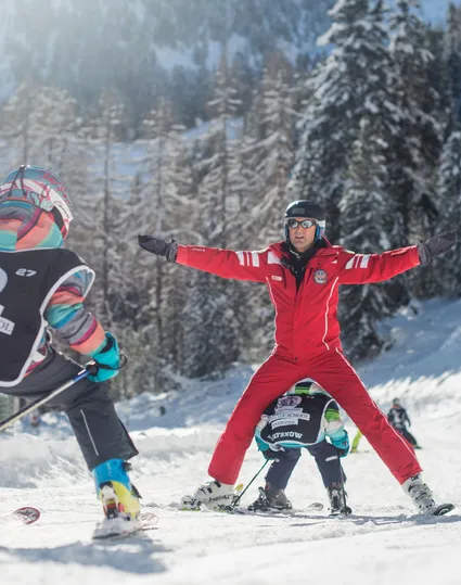 Skikurs für Kinder mit Skilehrer der Skischule Speikboden auf verschneiter Piste im Ahrntal
