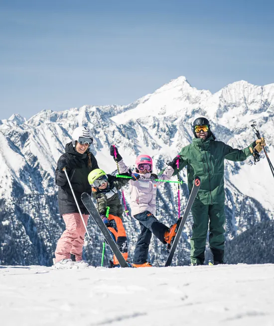 Skiurlaub mit der Familie am Klausberg – vier Familienmitglieder in Skiausrüstung vor Alpenpanorama