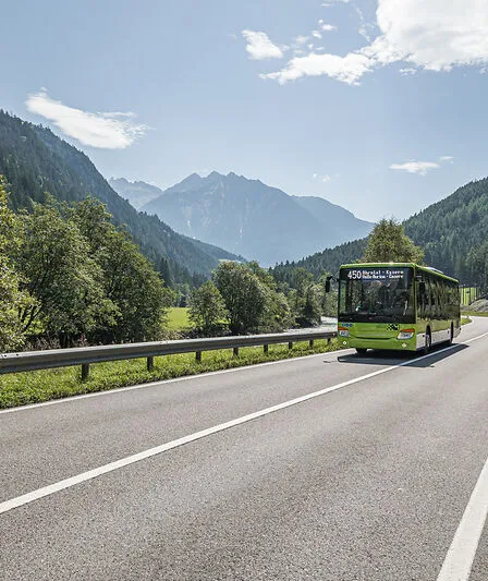 Südtiroler Linienbus Linie 450 Ahrntal–Kasern im grünen Sommertal vor Bergkulisse