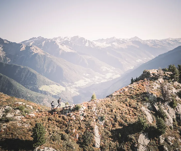 Zwei Wanderer auf herbstlichem Bergrücken am Speikboden mit Blick ins grüne Ahrntal