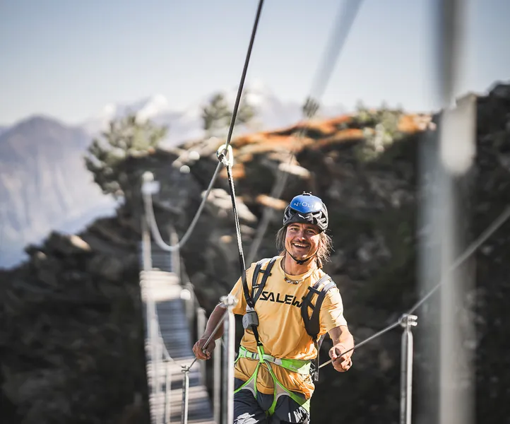 Junger Kletterer auf Hängebrücke am Klettersteig Klausberg mit Blick auf die Tauern