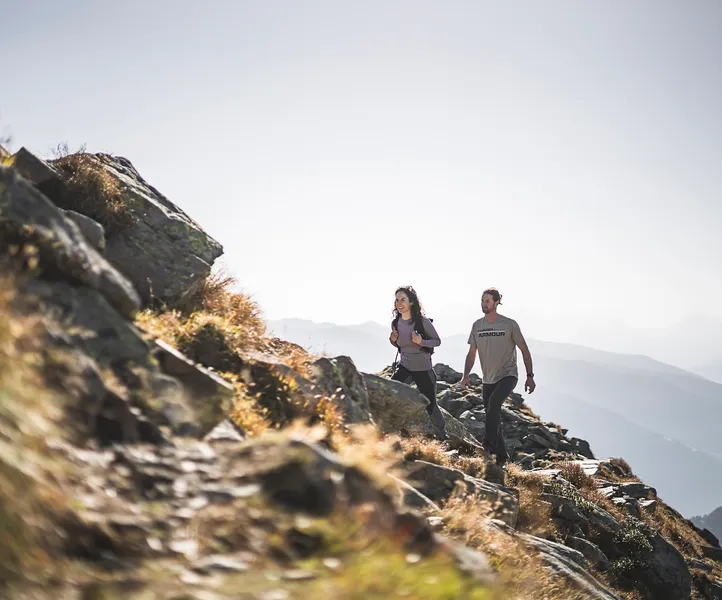 Wanderpaar auf felsigem Bergpfad mit Panoramablick über die Zillertaler Alpen im Ahrntal