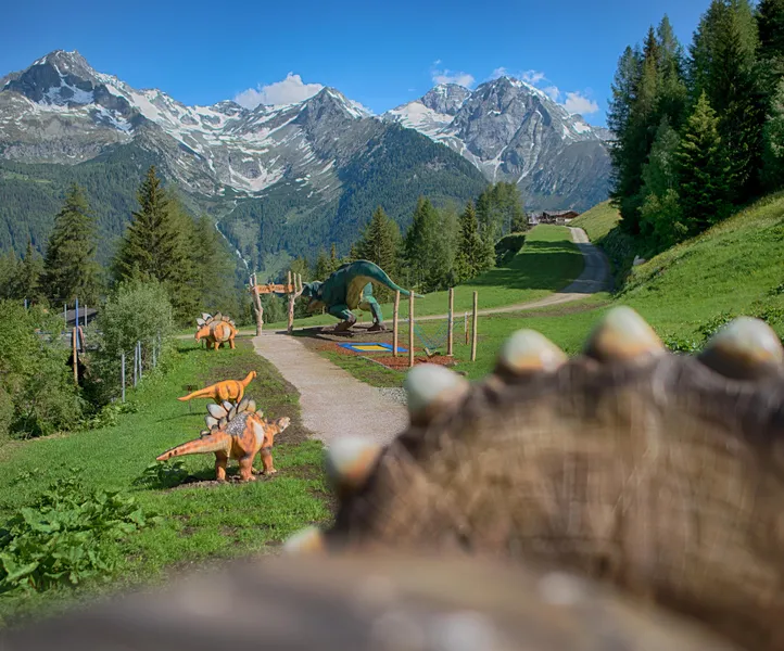 Klaussi's Dinopark am Klausberg: Dinosaurier-Figuren auf Almwiese vor beeindruckendem Bergpanorama