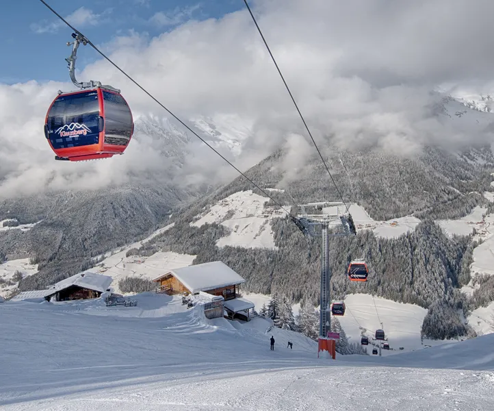 Skifahrer beim dynamischen Carvingschwung auf der Klausberg-Piste, Zillertaler Alpen im Hintergrund