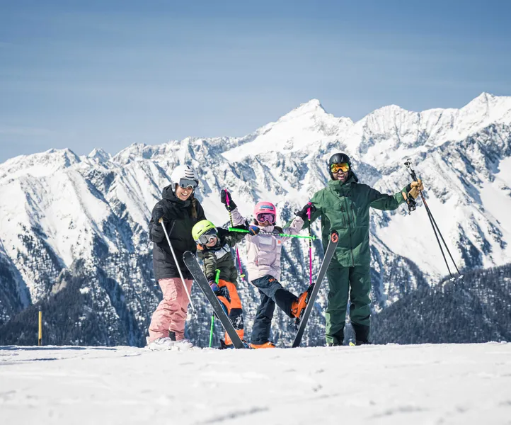 Skiurlaub mit der Familie am Klausberg – vier Familienmitglieder in Skiausrüstung vor Alpenpanorama